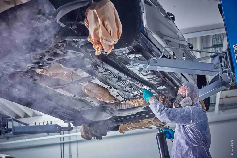 Hohlraumversiegelung wird in einen Autoschweller gesprüht
